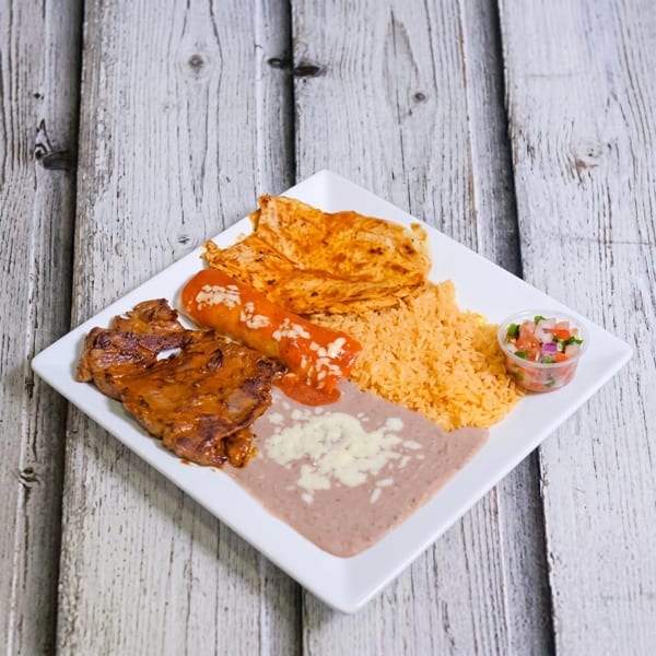 A white square plate holds a Mexican combination meal with steak, enchilada, rice, beans, and pico de gallo.